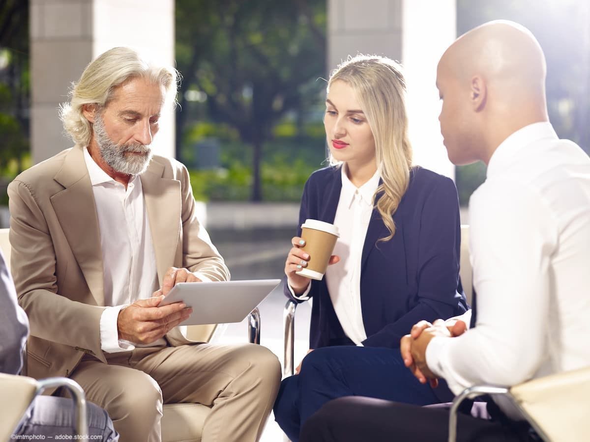 Three business people in group discussion Image Credit: AdobeStock/imtmphoto