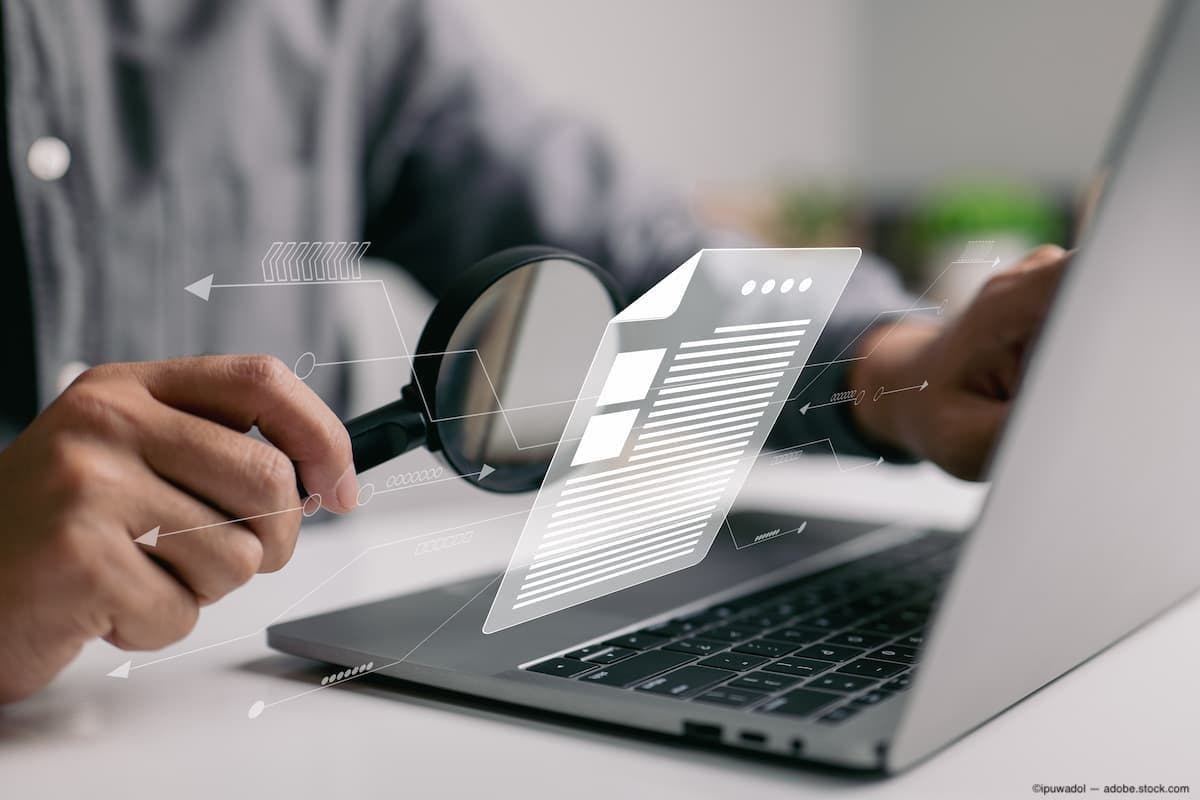 Magnifier held to laptop with document graphic Image Credit: AdobeStock/ipuwadol