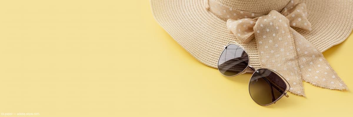 Sunglasses and straw hat on yellow background Image credit: AdobeStock/Lyubov