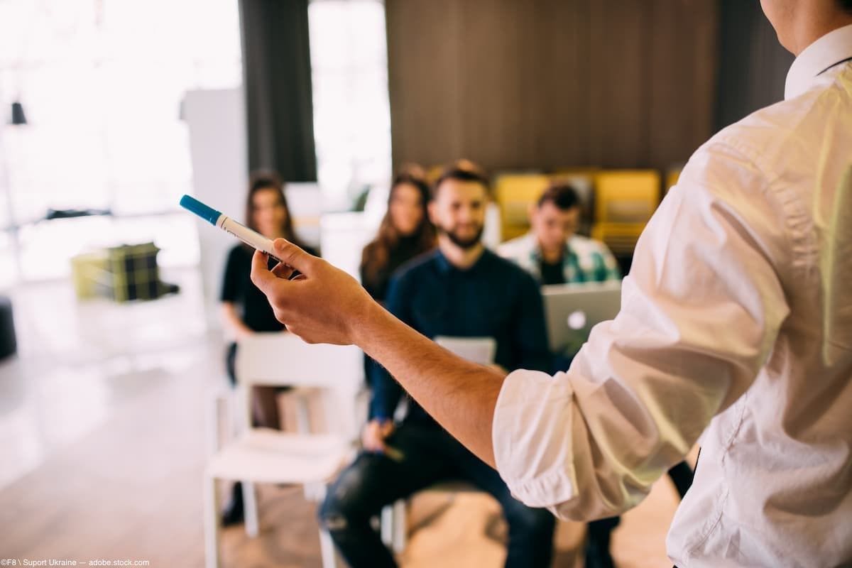 Man facing audience holding marker and lecturing Image credit: AdobeStock/F8\SuportUkraine