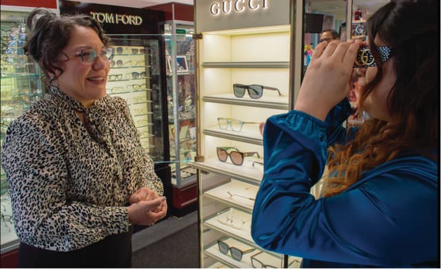 Diana Canto-Sims, OD (left) helps a patient try on frames at her practice Buena Vista Optical Boutique. Image courtesy of David Hidalgo.