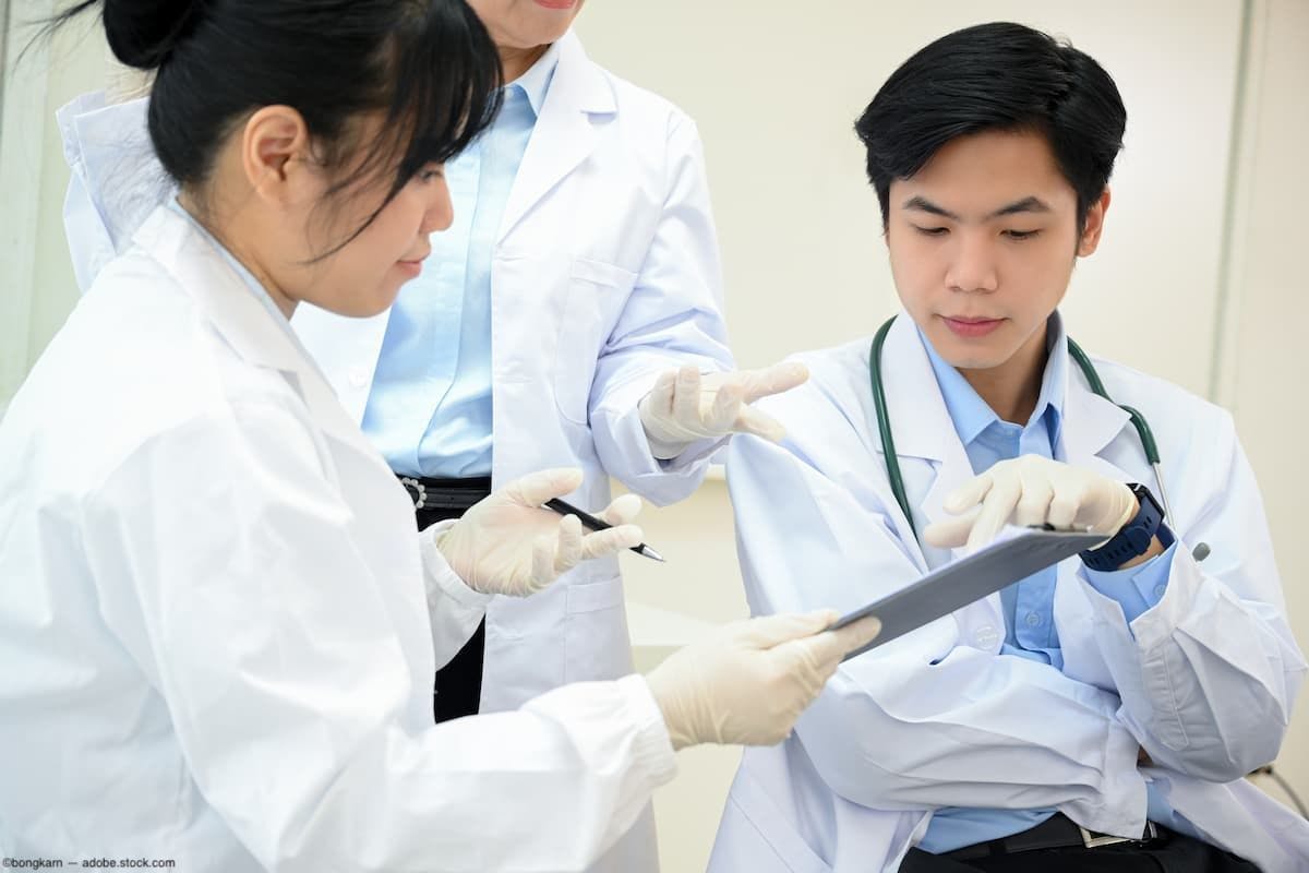 Group of doctors discussing case findings on clipboard Image credit: ©bongkarn - adobe.stock.com