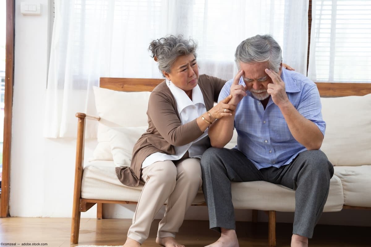 Wife consoles husband suffering from memory loss on couch Image credit: ©comzeal - adobe.stock.com