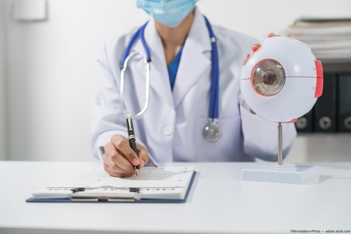 Eye doctor at desk with clipboard and eye model Image credit: ©M+Isolation+Photo - adobe.stock.com