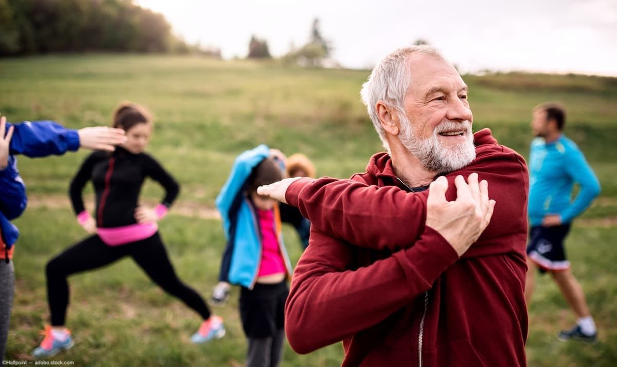 People stretching in a field Image credit: AdobeStock/Halfpoint