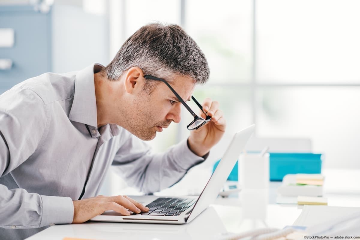 Nearsighted office worker looking at computer with glasses Image credit: ©StockPhotoPro - adobe.stock.com